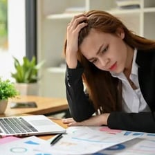 A person appearing worried and stressed while sitting at a desk.