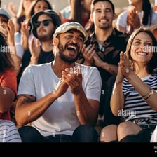 Spectators watching a sporting event from beside the playing area.
