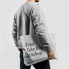 A person carrying a tote bag by its handles.