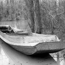 A small wooden bateau floating on a Louisiana bayou