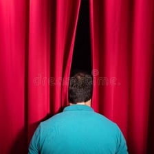 A person coming back into view from behind a curtain.