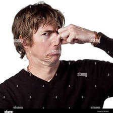 A person pinching their nose in response to an unpleasant odor