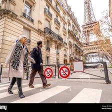 A person walking on a Paris street with the Eiffel Tower nearby