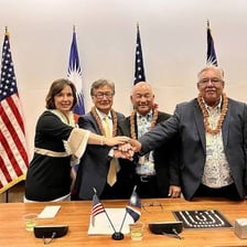People signing an agreement during a formal official ceremony