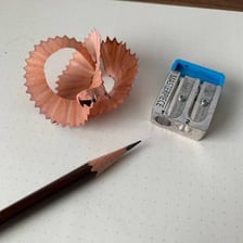 Pencil sharpeners beside freshly sharpened pencils