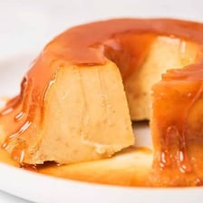 A flan dessert topped with glossy caramel sauce.