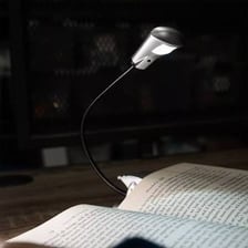 A reading lamp shining on an open book.