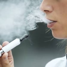 A person using a small electronic cigarette