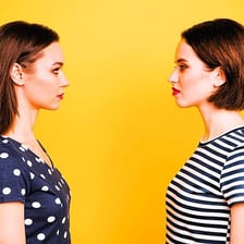 A person displaying jealousy while watching someone else receive praise.