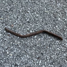 A straight-looking metal rod shown bent into a crooked shape.
