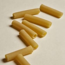 Hollow, tube-shaped ziti pasta arranged on a surface.