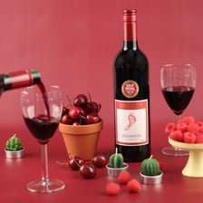 A bottle of California zinfandel wine beside grapes.