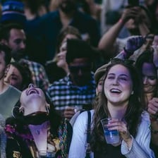 A person covering their ears near loud speakers
