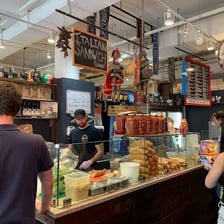 The storefront and counter of a deli selling sandwiches.
