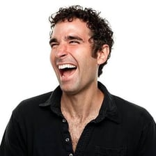 A person laughing with an amused expression