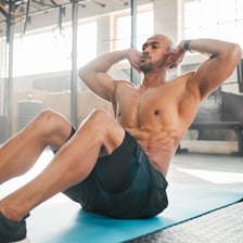 A person performing a sit-up to exercise the abdominal muscles.