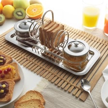 A jar of marmalade served with toast on a tea tray.