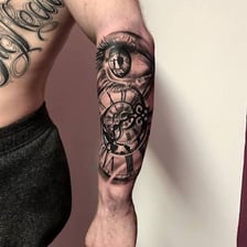 A close view of a forearm bearing tattoos.