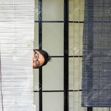 A person concealed behind a curtain.