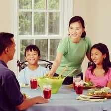 People beginning a meal at a dining table.