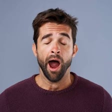 A person yawning and appearing bored.