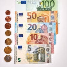 Euro banknotes and coins arranged together.
