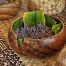 A bowl of thick purple-gray Hawaiian poi served at a luau