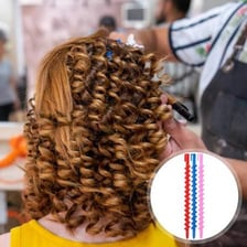 A hairstylist applying a perm with hair curlers