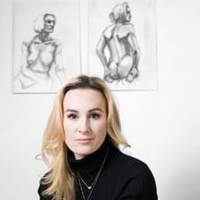 An art class focused on drawing a seated human figure model.