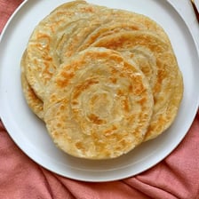Round roti flatbreads arranged on a plate.