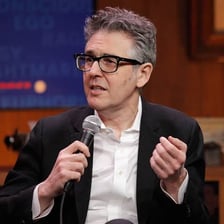 Ira Glass speaking into a microphone during a radio recording