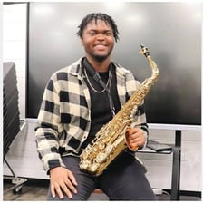A musician playing an alto saxophone.