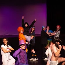 Performers acting out a short comedy skit onstage