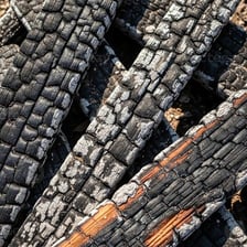 Piece of wood blackened and scorched by intense heat