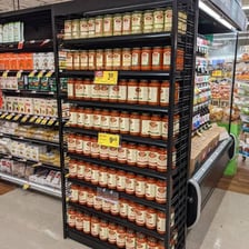 A supermarket aisle lined with grocery shelves.