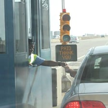 Car approaching a toll booth on a roadway