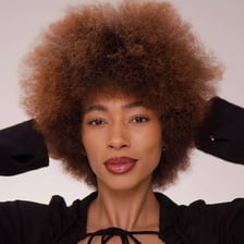 A person wearing a rounded afro hairstyle.