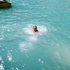 A person briefly swimming in a lake