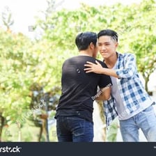 Two friends greeting each other outdoors.