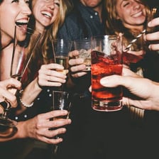 A person being served a drink at a bar