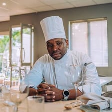 A chef wearing a white apron while cooking in a kitchen