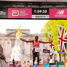 A marathon runner crossing the finish line while a stopwatch records the time