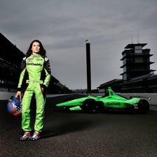 Danica Patrick driving a race car on a speedway.