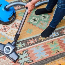 A vacuum cleaner being used on an area rug