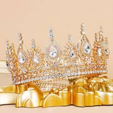 A jeweled royal crown displayed on a stand