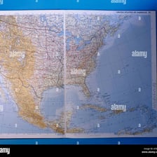 An open atlas showing maps across its pages.