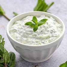A bowl of Indian cucumber raita made with yogurt and herbs.
