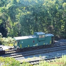 A caboose attached at the back of a train.