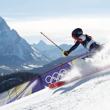 A skier racing down a snowy alpine course