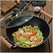 A round-bottomed wok being used to cook a stir-fry